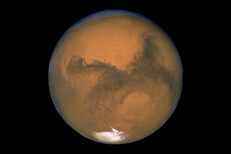 This Aug. 26, 2003, image made available by NASA shows Mars as it lines up with the Sun and the Earth. A new study suggests water on Mars may be more widespread and recent than previously thought. Scientists reported the finding from China's Mars rover in Science Advances on Friday, April 28, 2023. Credit: NASA/J. Bell - Cornell U./M. Wolff - SSI via AP, File