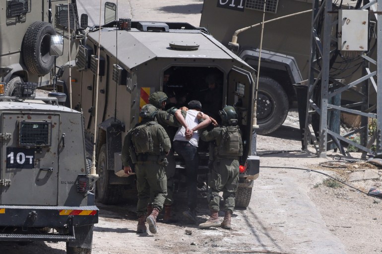 Israeli soldiers detain a Palestinian man during a raid in the occupied West Bank town of Deir al-Ghusun near Tulkarem on May 4, 2024. (Photo by JAAFAR ASHTIYEH / AFP)